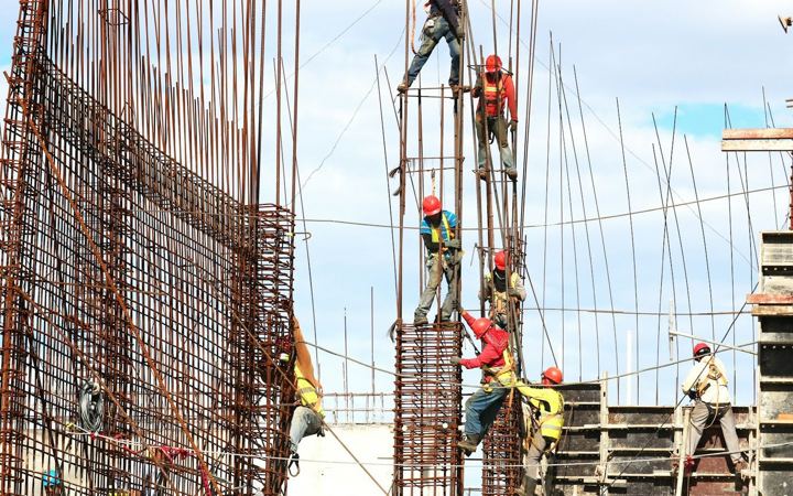 Ouvriers sur des armatures de poteaux en béton armé