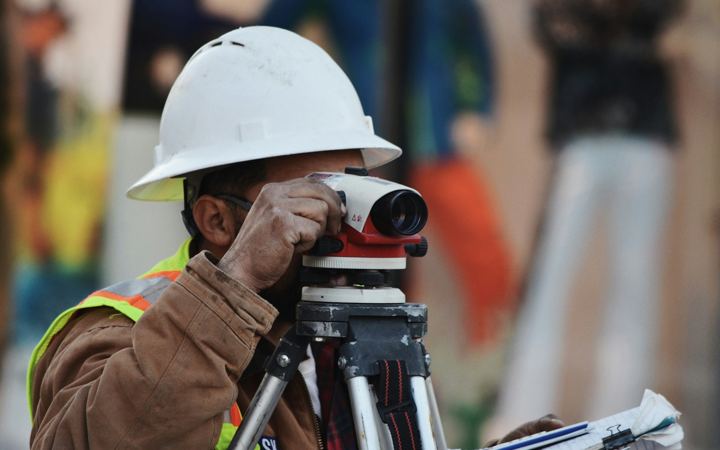 Ingénieur réalisant un relevé avec un niveau optique